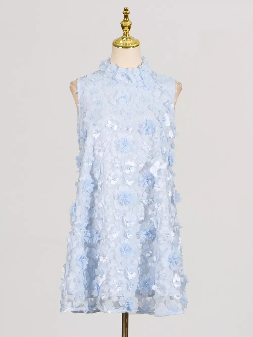 Blue floral applique mini dress with ruffled mock neck and sleeveless design.