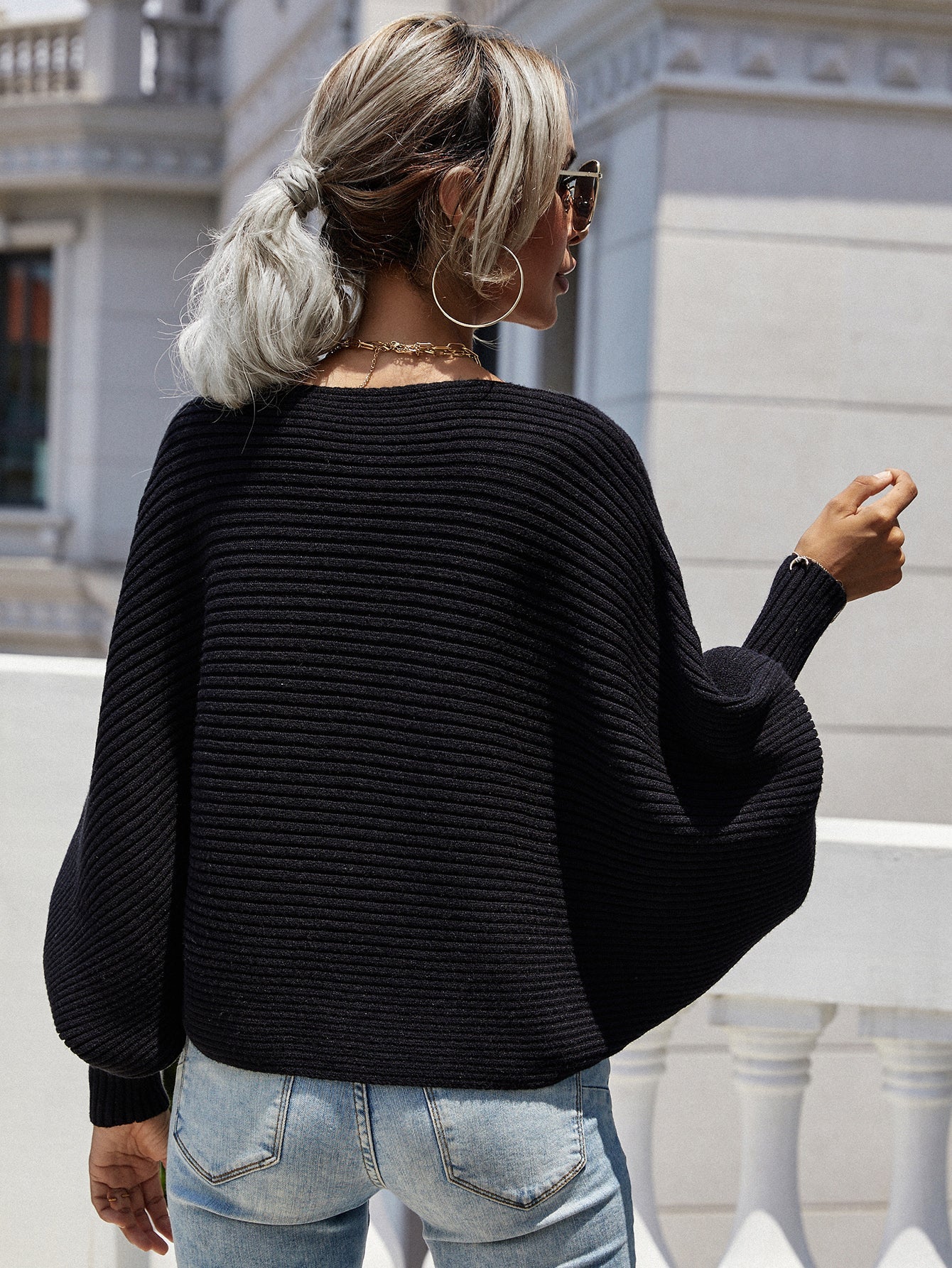 Black ribbed dolman knit sweater with boat neck and wide sleeves.