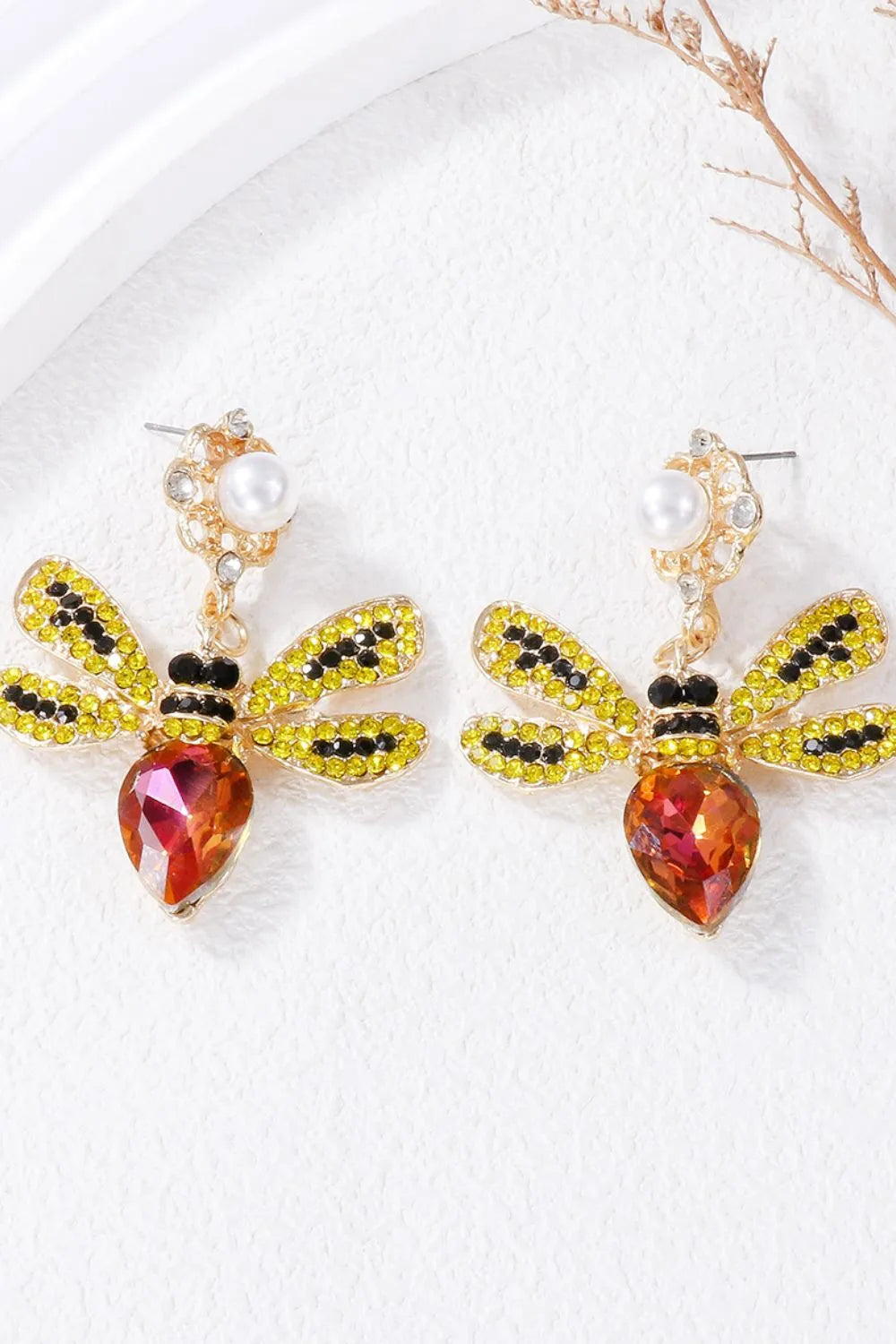 Gold chandelier earrings with jeweled dragonfly design and pearl accents.