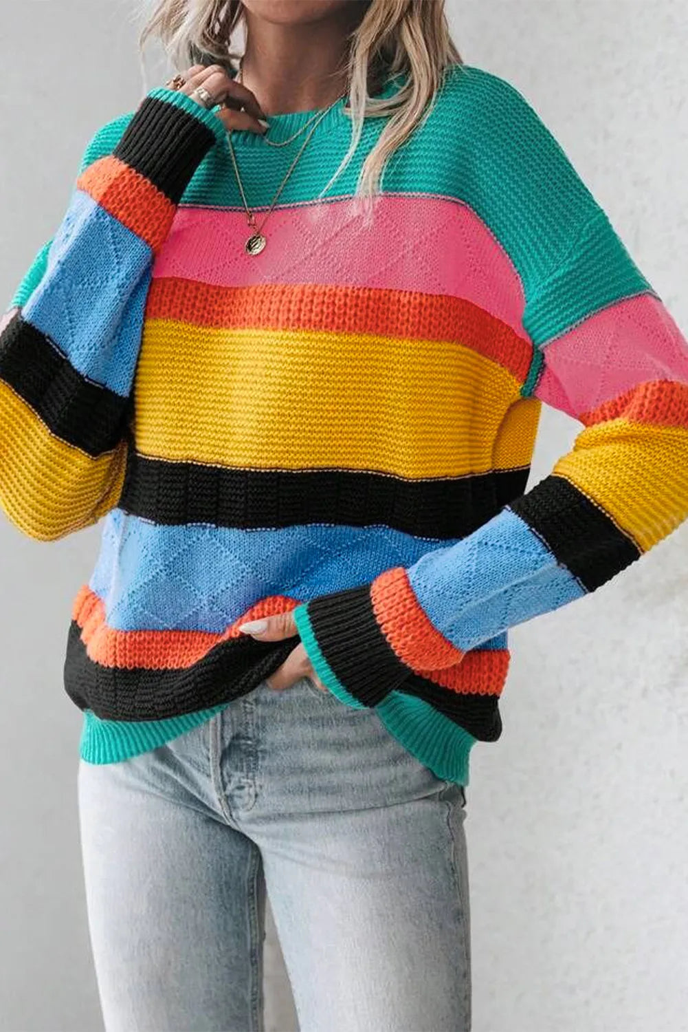 Rainbow stripe knit crewneck sweater with diamond pattern detail.