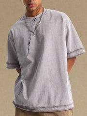Gray washed cotton t-shirt with raw edges and double-stitched sleeves.