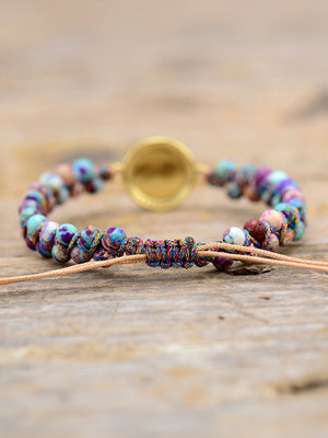 Multicolor beaded bracelet with iridescent orb and jasperite beads, adjustable cord closure.