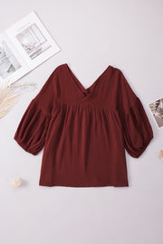 Textured gauze blouse in burnt coral with V-neck and gathered balloon sleeves.
