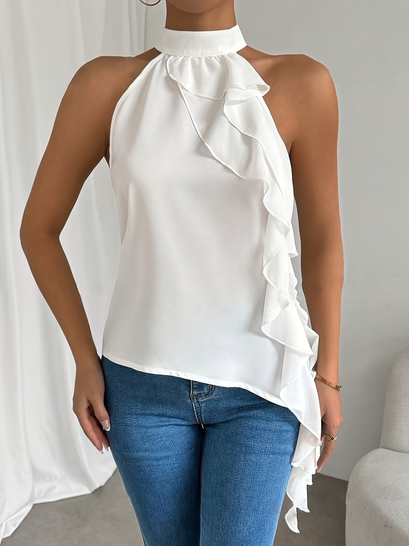White ruffled halter neck blouse with asymmetrical hem.