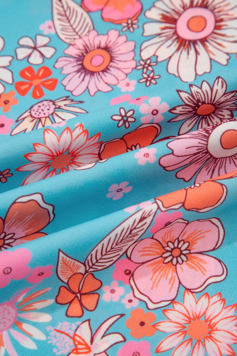Maxi dress with vibrant bohemian floral print in pink, orange, and white on a blue background.
