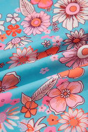Maxi dress with vibrant bohemian floral print in pink, orange, and white on a blue background.