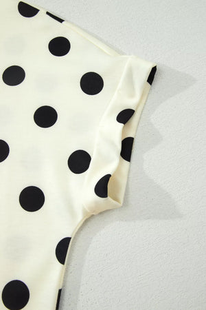 Cream polyester t-shirt with black polka dots and cuffed short sleeves.
