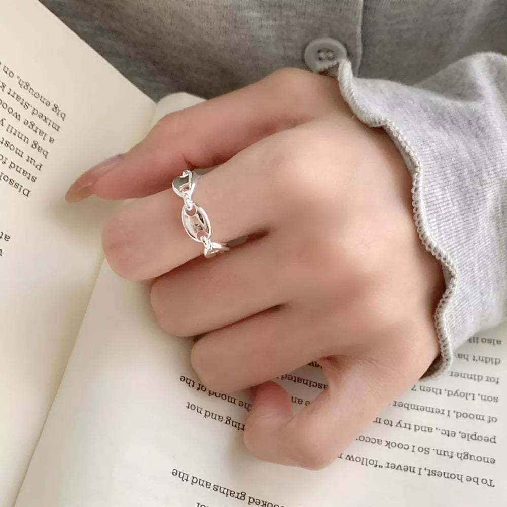 Sterling silver ring with interconnected oval links, delicate chain design.