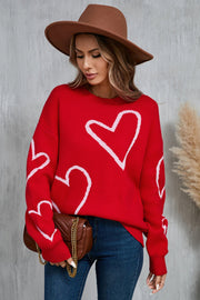 Red acrylic knit jumper with white outline hearts, crew neck, long sleeves.