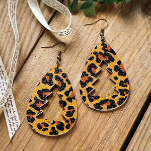 Leopard print teardrop earrings with tree cutouts and bronze hooks.