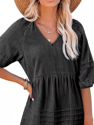 Dark blue denim mini dress with V-neck, puff sleeves, and tiered skirt.