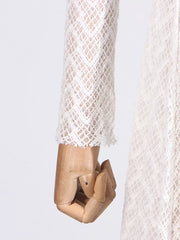 White lace maxi dress with mock neck and long sleeves, showing cuff detail.