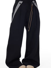 Men's black wide-leg cotton trousers with braided cord detail and houndstooth trim.