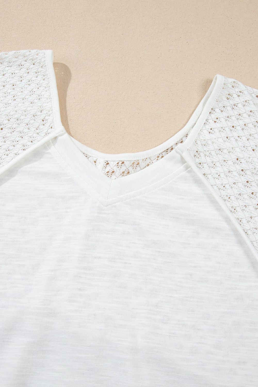 White blouse with lace inset dolman sleeves and V-neck detail