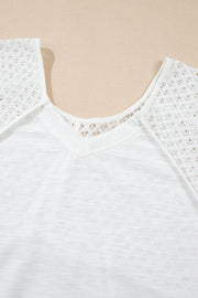 White blouse with lace inset dolman sleeves and V-neck detail