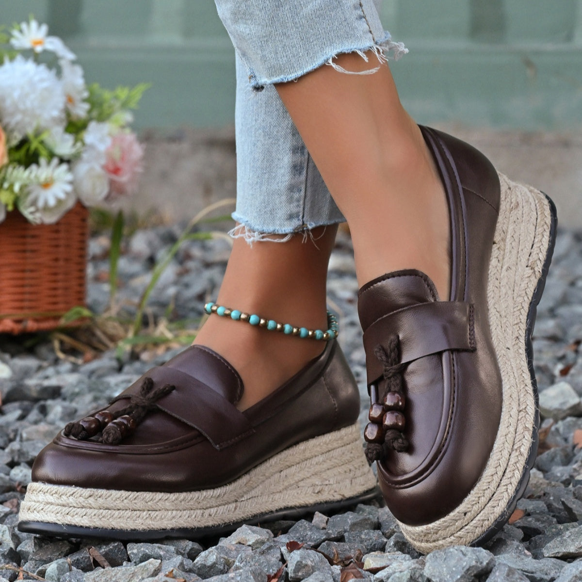 Brown leather espadrille wedge loafers with braided jute sole and tassel detail.