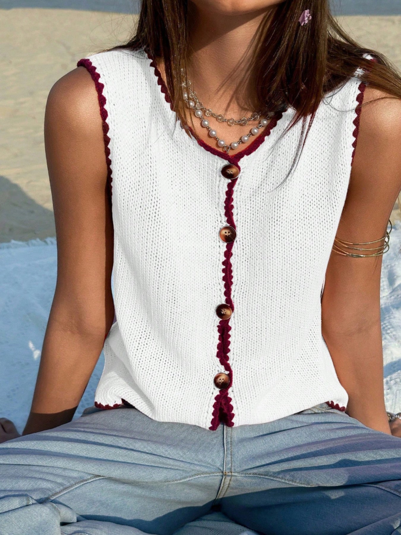 White button-down sweater vest with burgundy trim and buttons