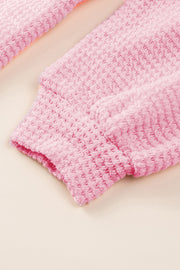 Blush pink waffle knit button-down shirt jacket detail showing textured fabric and cuff.