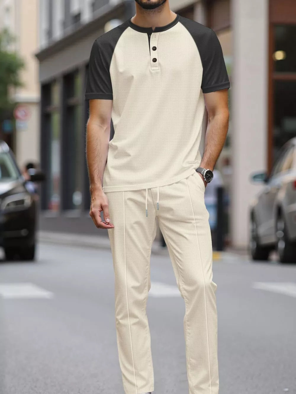 Men's beige loungewear set with a black raglan sleeve henley shirt and drawstring pants.