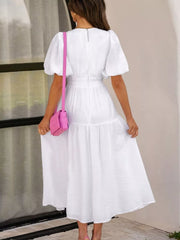White midi dress with puff sleeves, elastic waist, and tiered skirt.