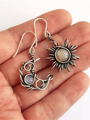 Celestial wirework mismatched drop earrings in silver with moon and sun charms.