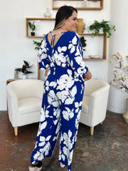 Cobalt blue floral kimono jumpsuit with tie-back detail and wide legs.