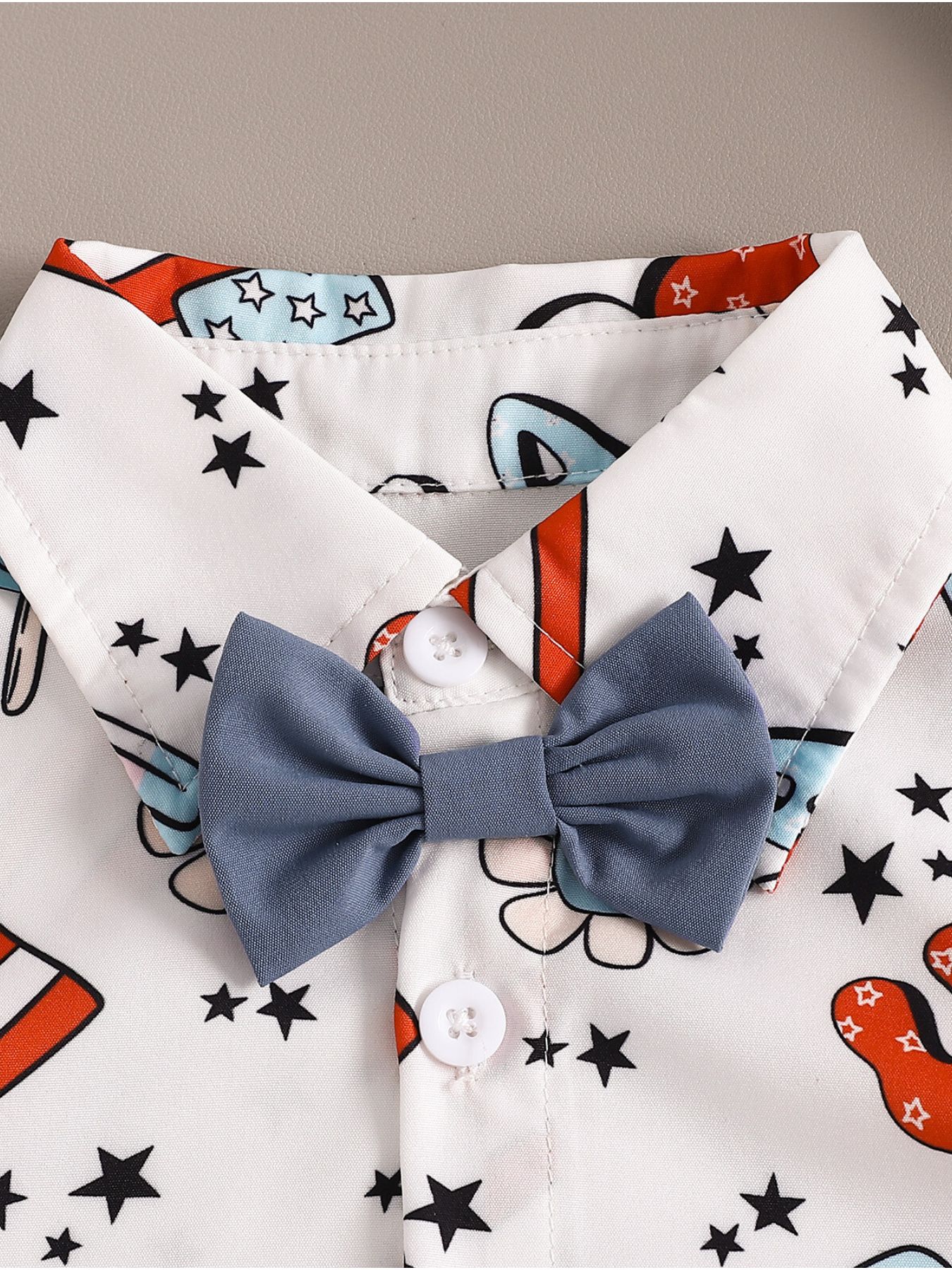 Toddler white cotton shirt with stars and patriotic print, featuring a blue bow tie.