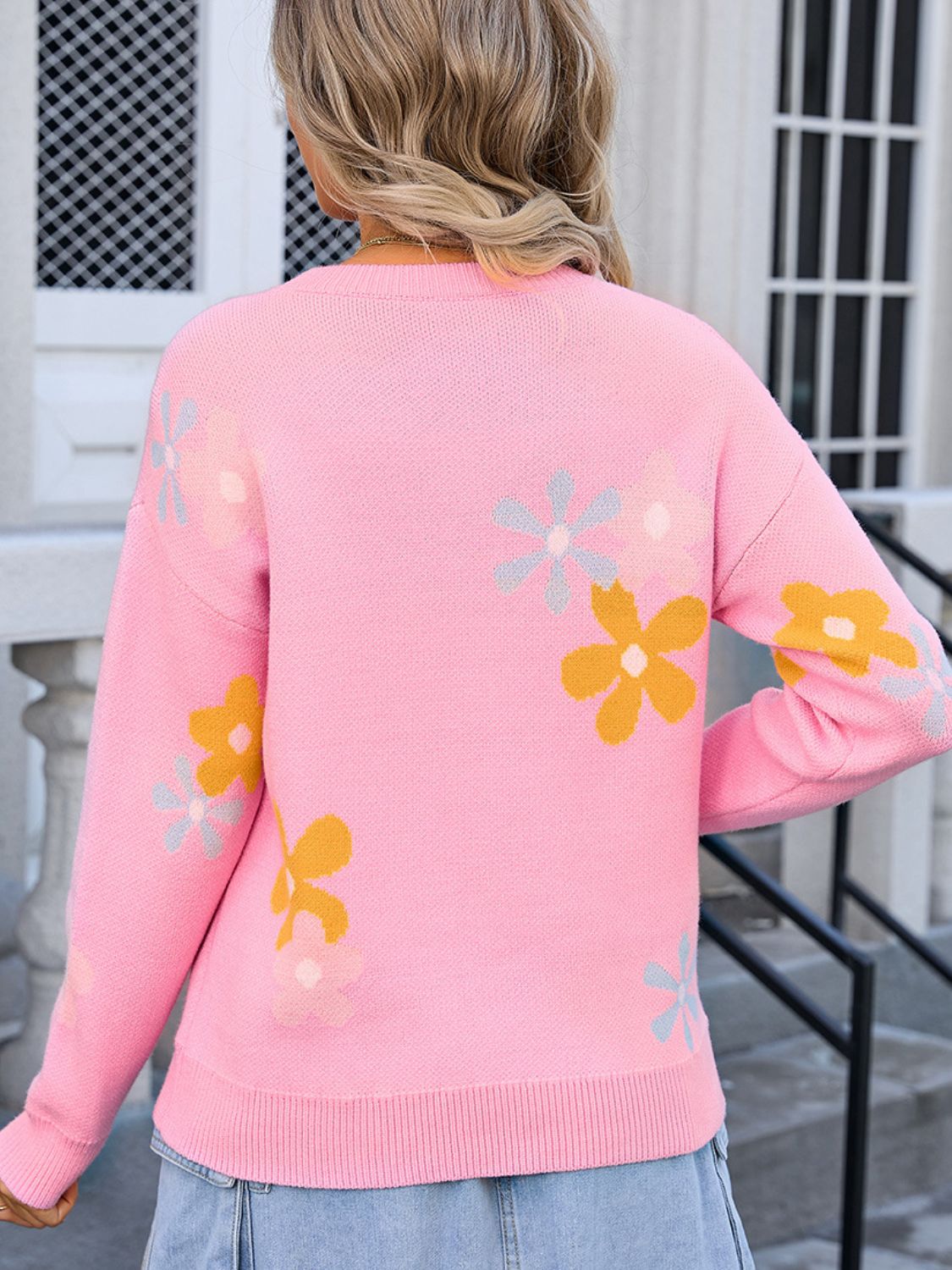 Pink acrylic knit crewneck pullover sweater with intarsia floral pattern.