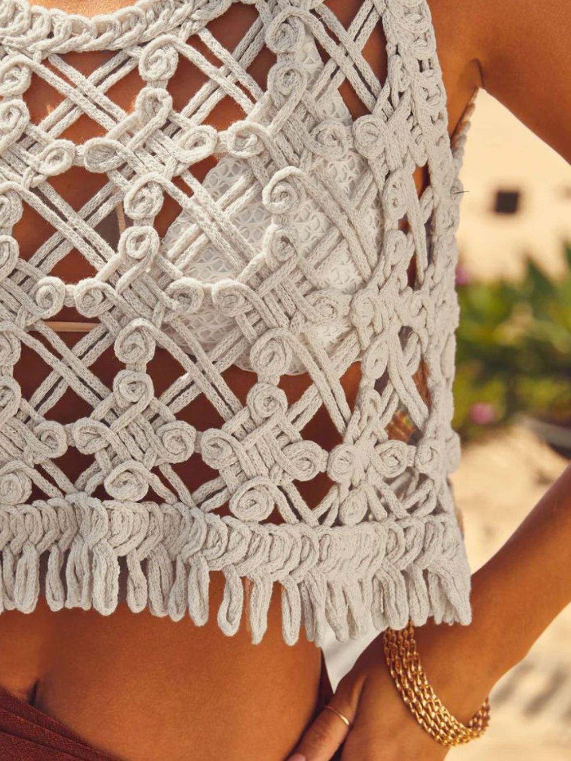 Tan macramé crop top with fringe hem and intricate woven detail.