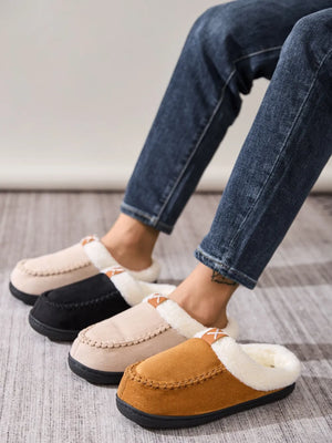Suede shearling-lined moccasin slides in caramel, khaki, and black with decorative stitching.