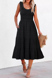 Black smocked tiered midi dress with pockets and square neckline.