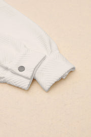 Textured ivory overshirt detail showing cuff and button closure.