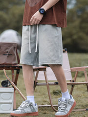 Light blue relaxed fit denim shorts with drawstring waist and pockets.
