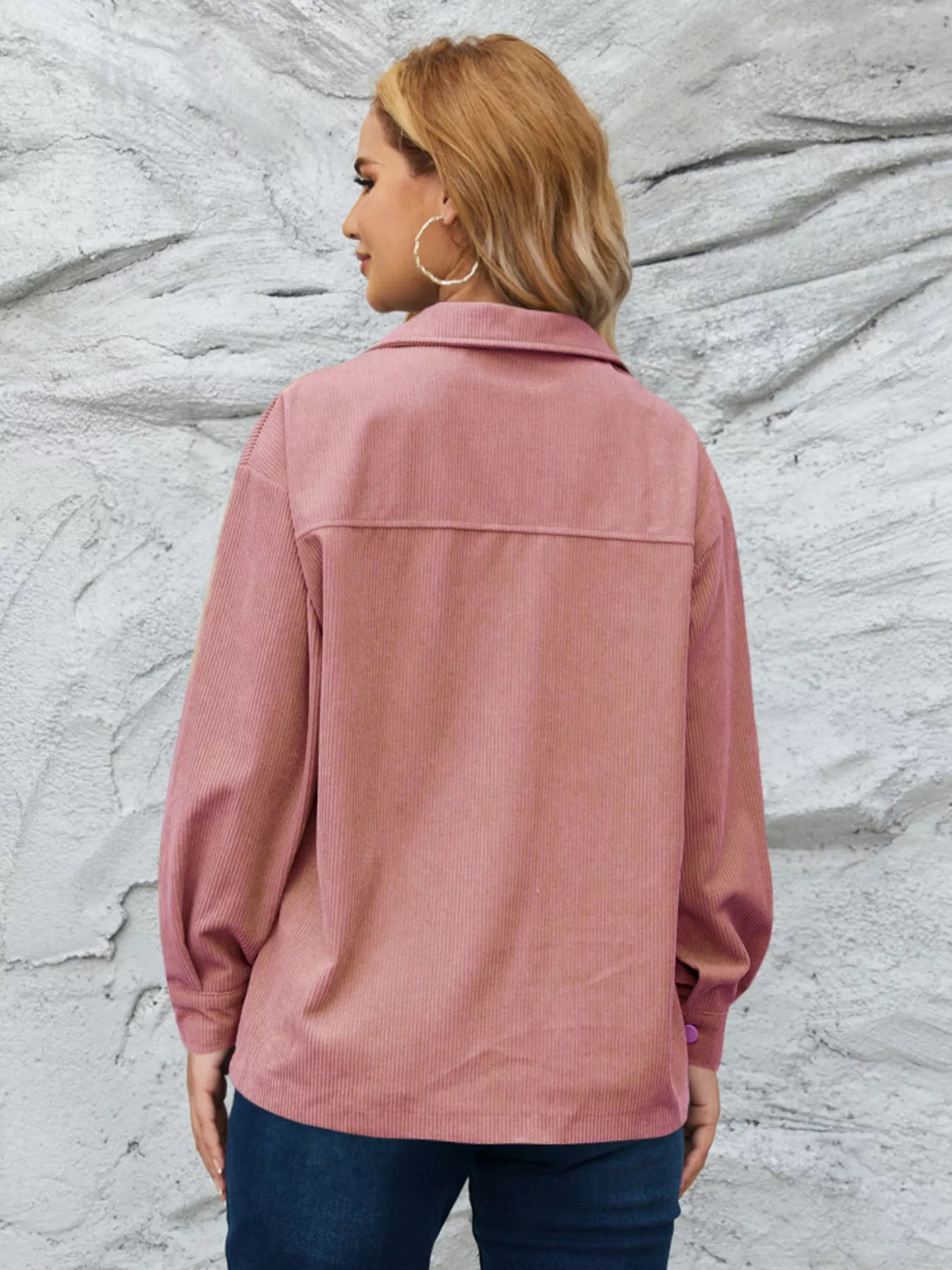 Pinkish corduroy button-up jacket with textured fabric and a classic collar.