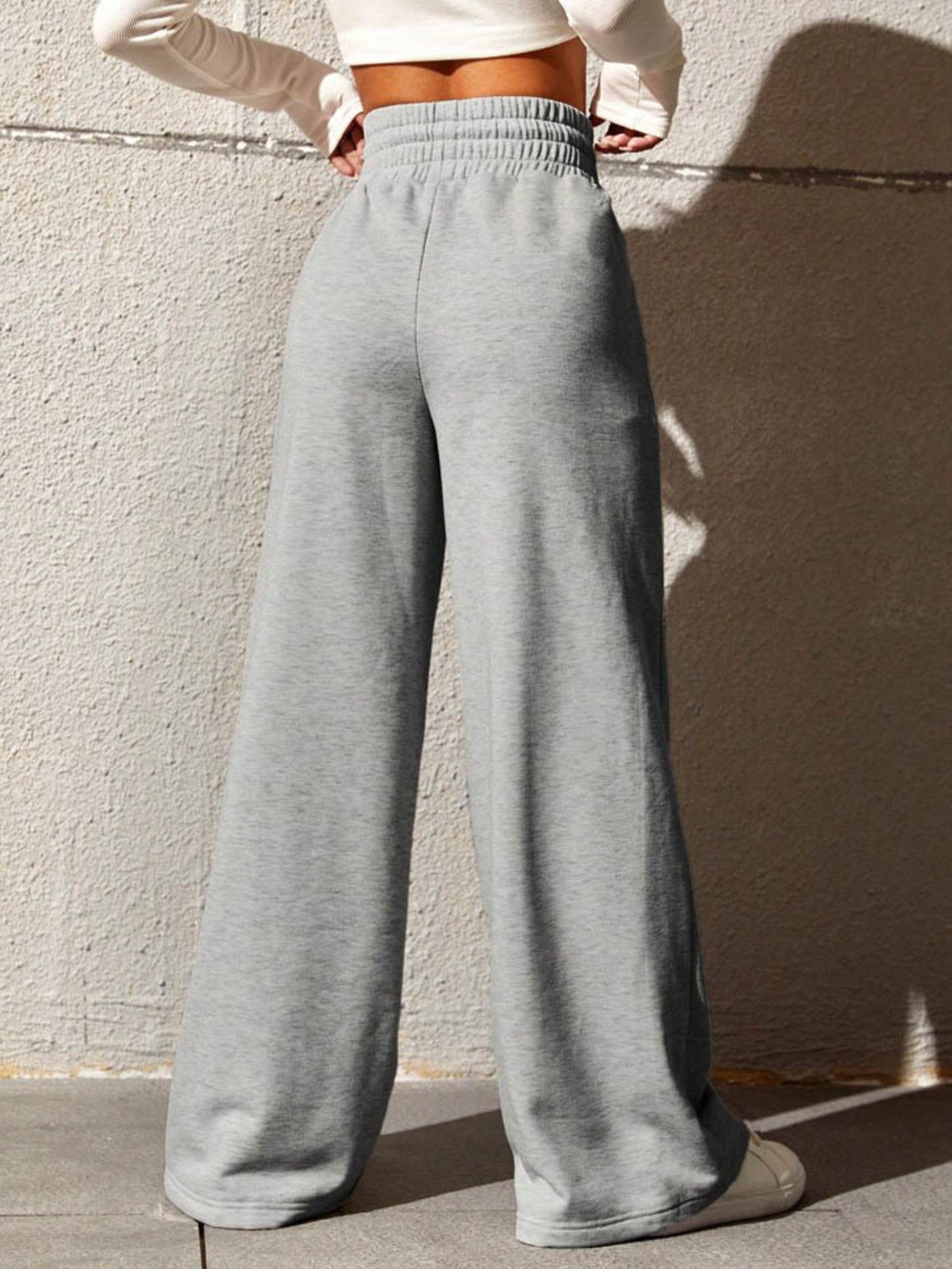 Gray sweatpants with drawstring waist and wide legs.
