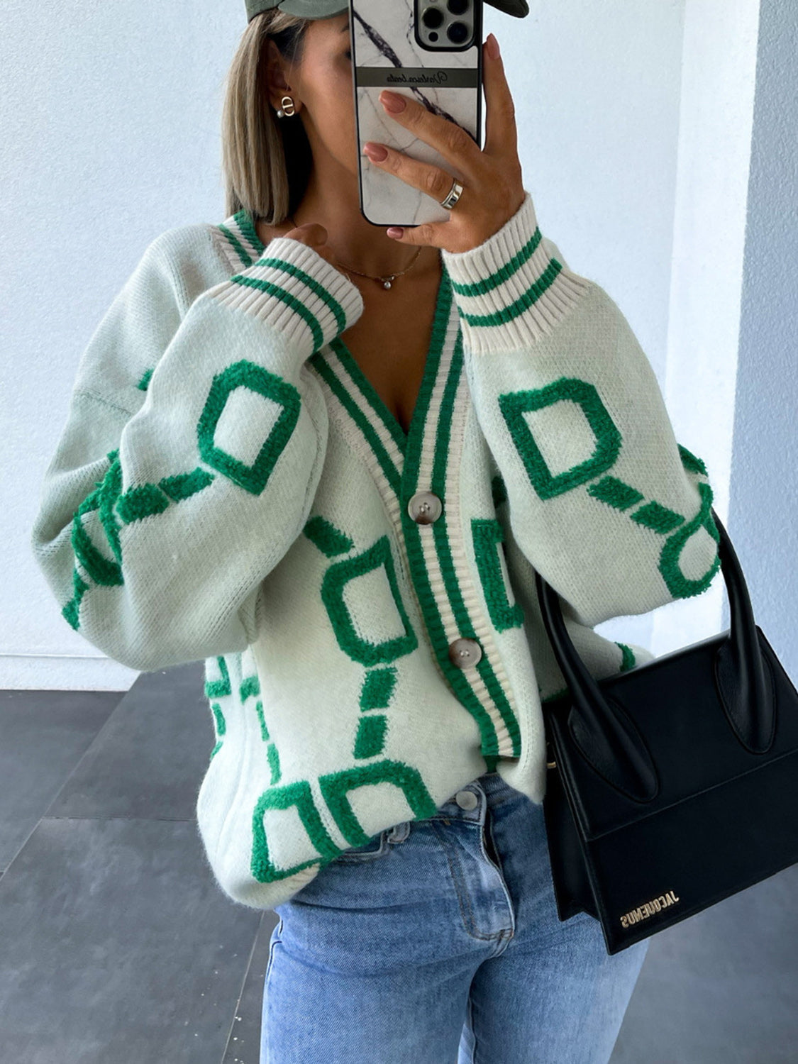White acrylic geometric chain knit cardigan with green trim and buttons.