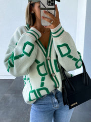 White acrylic geometric chain knit cardigan with green trim and buttons.