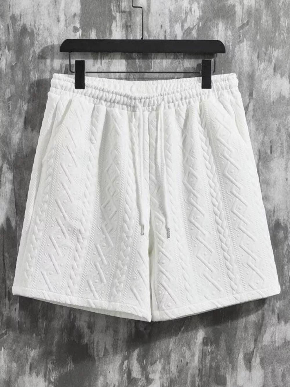 White textured knit shorts with drawstring waist and cable knit pattern detail.