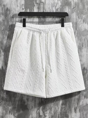 White textured knit shorts with drawstring waist and cable knit pattern detail.