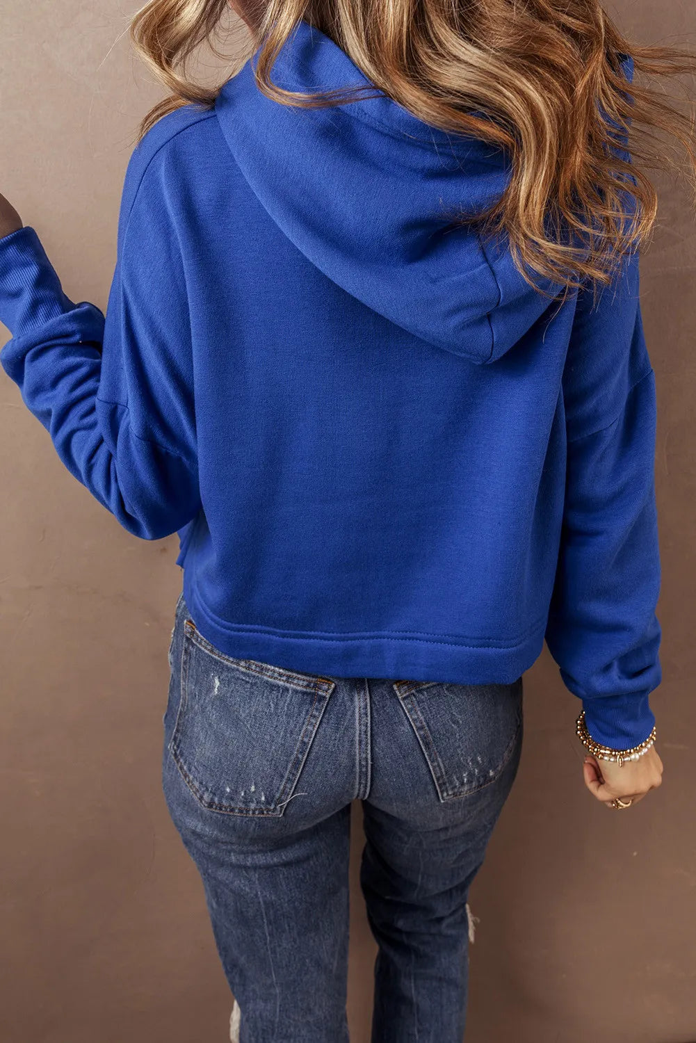Cobalt cropped hoodie with hood and long sleeves, shown from the back.