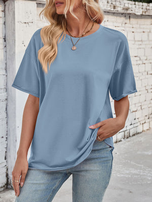 Oversized dusty blue cotton tee with seam details and rolled sleeves.