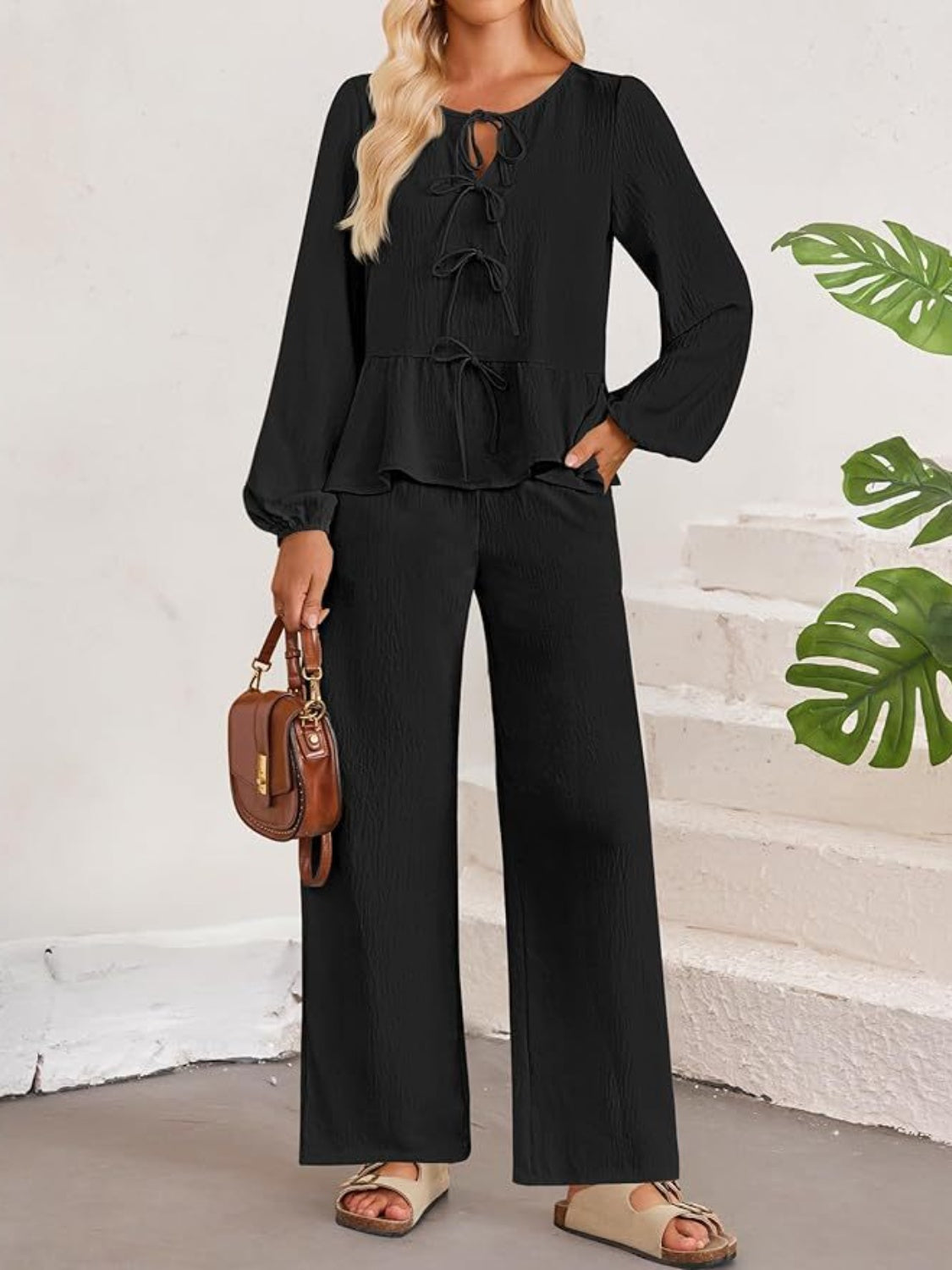 Black textured peplum tie-neck co-ord set with balloon sleeves and wide-leg pants.