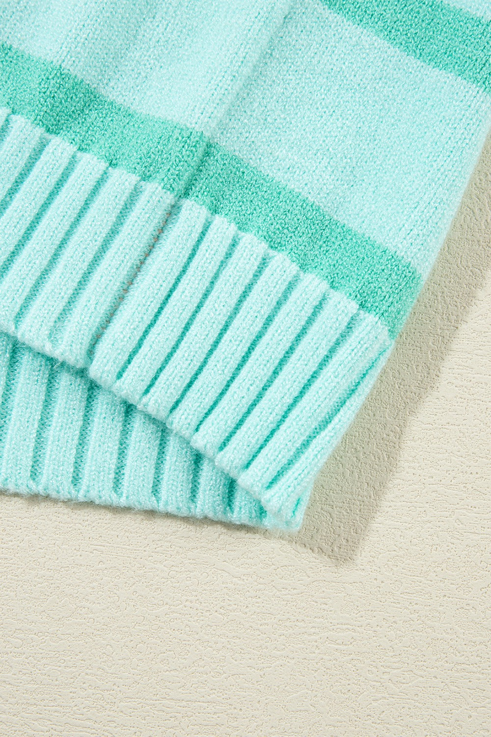Ombre stripe knit sweater in turquoise with ribbed cuffs and neckline detail.
