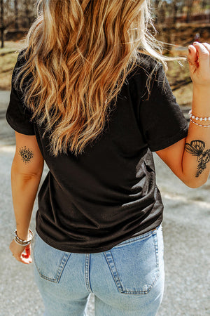 Black t-shirt with short sleeves and a relaxed fit, styled with light wash denim jeans.