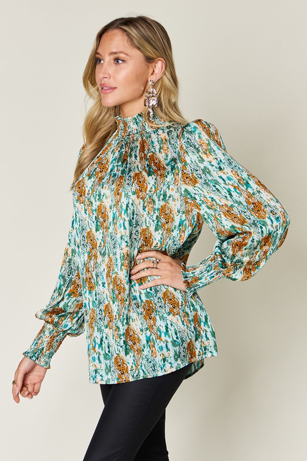 High neck abstract print blouse in green with long puff sleeves and smocked cuffs.