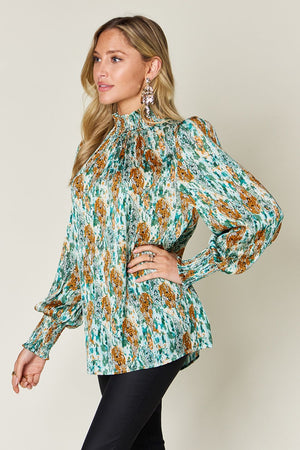 High neck abstract print blouse in green with long puff sleeves and smocked cuffs.