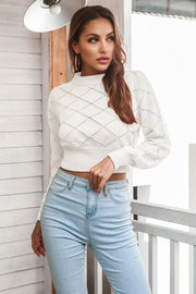 White diamond knit cropped sweater with mock neck and long sleeves.