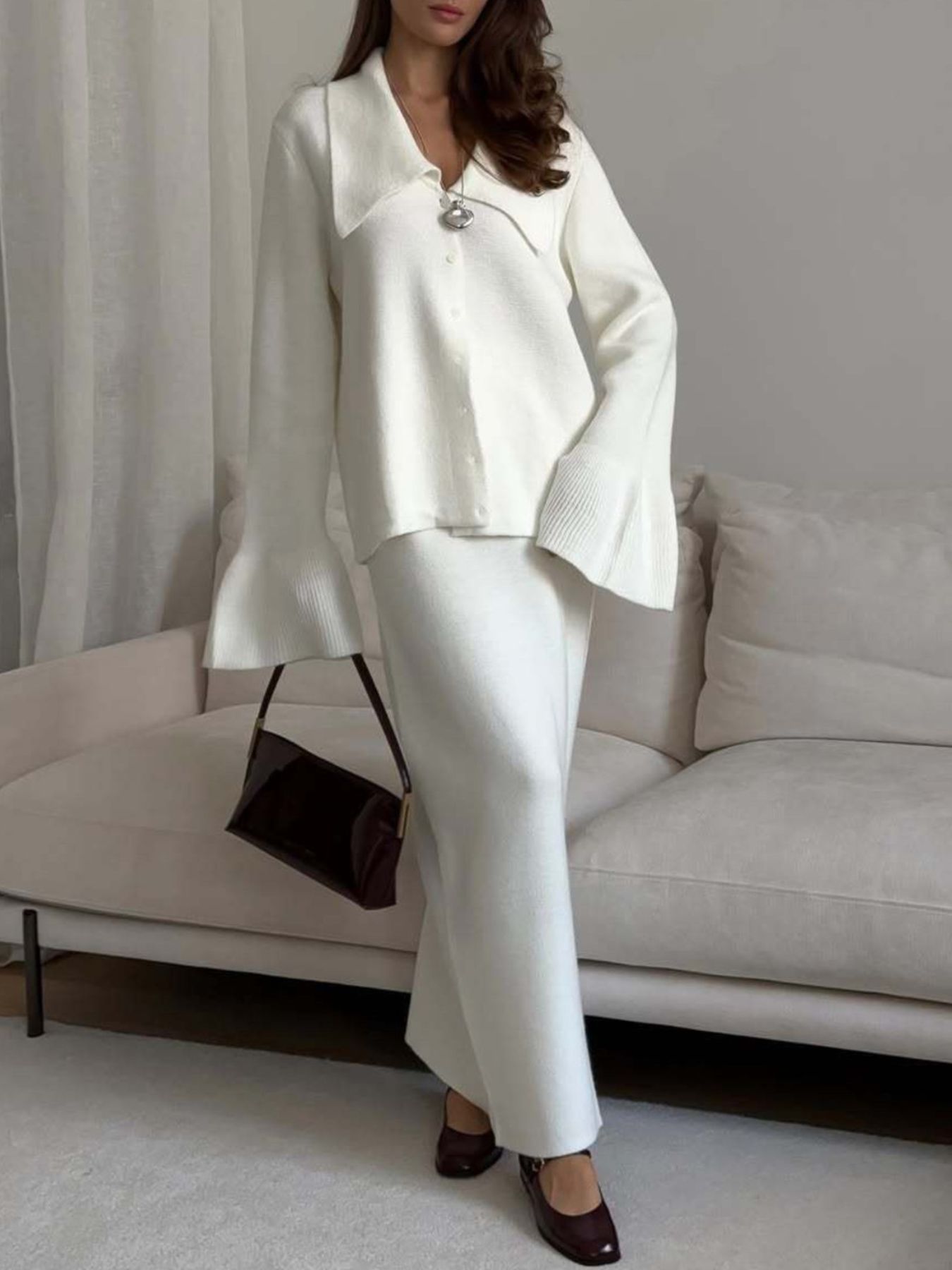 Milky white ribbed knit cardigan with flared sleeves and button-down front paired with matching midi skirt.