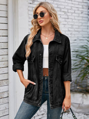 Black oversized denim trucker jacket with rolled sleeves and buttoned pockets.