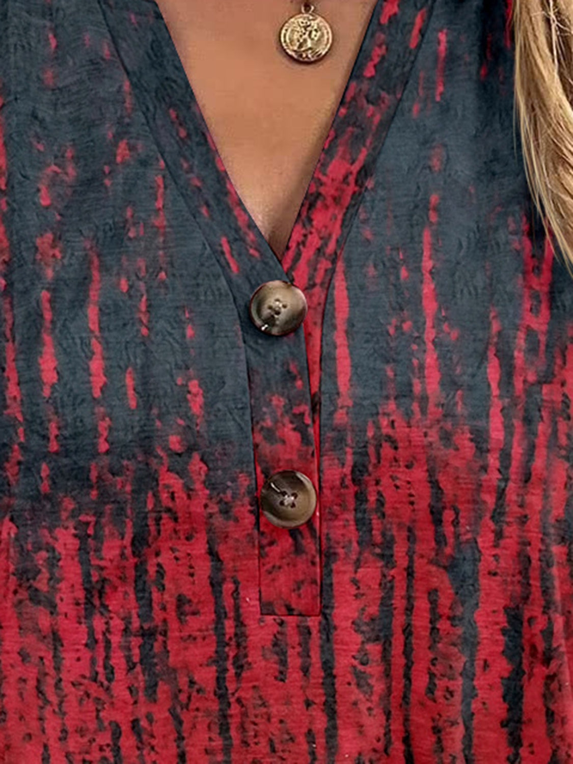 Bohemian tapestry henley blouse with a V-neck and button detail in a red and black tie-dye pattern.